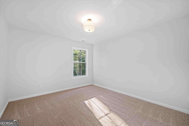 spare room featuring carpet and baseboards
