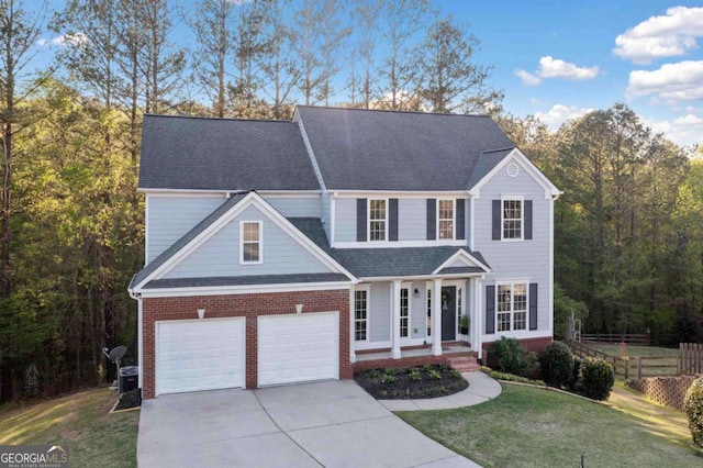 traditional-style home with a garage, concrete driveway, brick siding, a porch, and roof with shingles