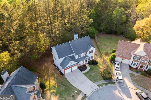 aerial view of property and surrounding area featuring a forest