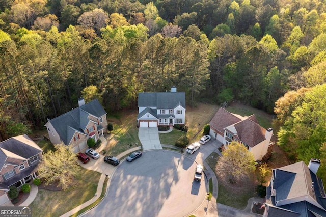 aerial view of property's location with a heavily wooded area and nearby suburban area