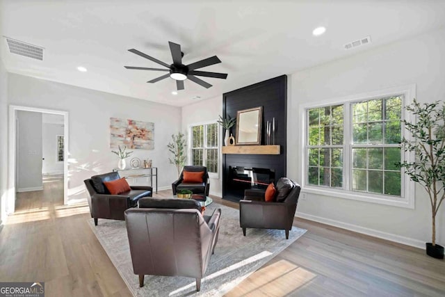 living room featuring ceiling fan, baseboards, wood finished floors, and recessed lighting