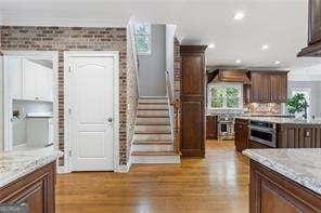 kitchen featuring recessed lighting, dark brown cabinetry, light wood-type flooring, and oven