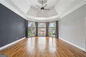 unfurnished room featuring baseboards, basketball hoop, coffered ceiling, and ceiling fan