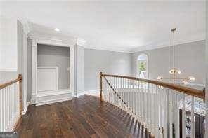 corridor featuring an upstairs landing and wood finished floors