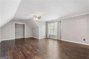 bonus room with baseboards and vaulted ceiling