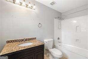 full bath with toilet, vanity, and shower / bathtub combination