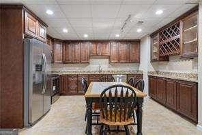kitchen featuring stainless steel fridge with ice dispenser, recessed lighting, light countertops, and dark brown cabinets