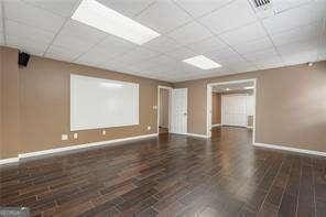 interior space with a paneled ceiling, baseboards, and visible vents