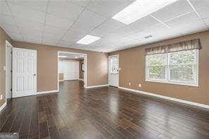spare room with baseboards and a drop ceiling