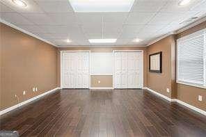 unfurnished bedroom with crown molding, wood finished floors, and baseboards
