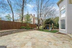 view of patio with fence and a playground