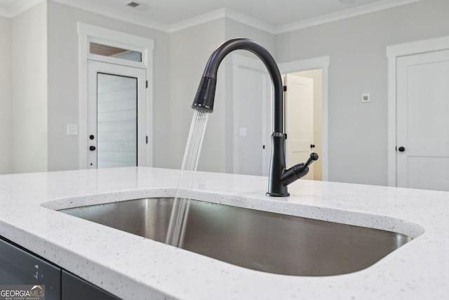 details featuring visible vents, ornamental molding, a sink, and light stone counters