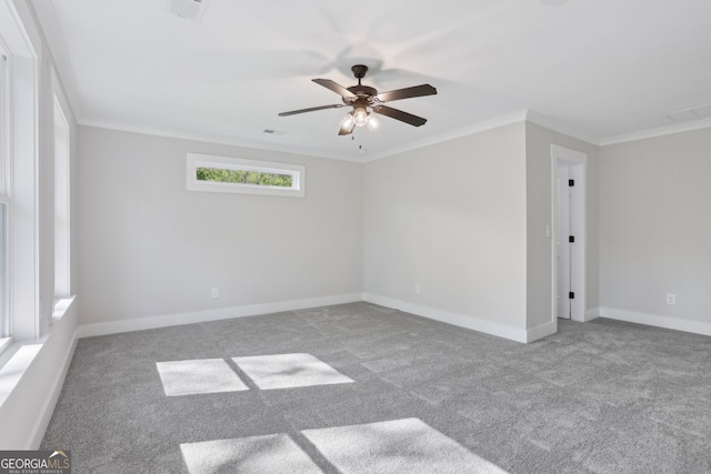 unfurnished room featuring baseboards, crown molding, carpet floors, visible vents, and ceiling fan