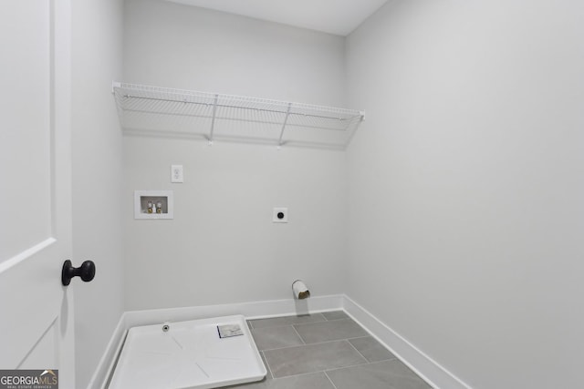 laundry room featuring hookup for an electric dryer, dark tile patterned floors, baseboards, washer hookup, and laundry area