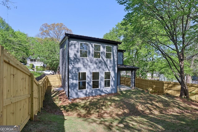 rear view of property with a fenced backyard