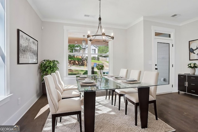 dining area with dark wood-type flooring, crown molding, an inviting chandelier, and visible vents