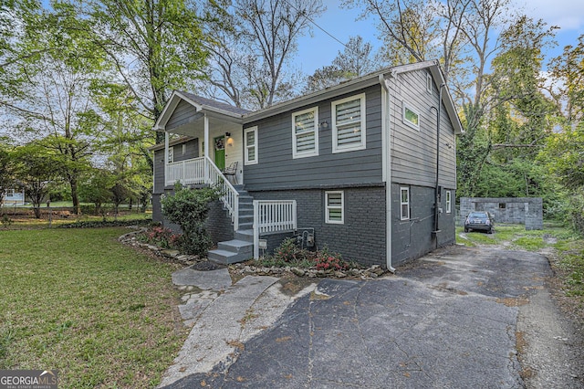 196 Wadley St NW, Atlanta, GA 30314 - view of front of property featuring a front yard, covered porch, brick siding, and asphalt driveway
