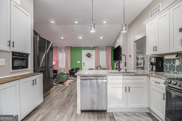 196 Wadley St NW, Atlanta, GA 30314 - kitchen with black appliances, a peninsula, light wood-style floors, white cabinetry, and recessed lighting