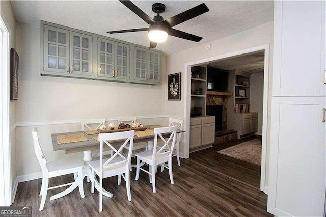 dining space featuring breakfast area, a ceiling fan, a textured ceiling, and dark wood-type flooring