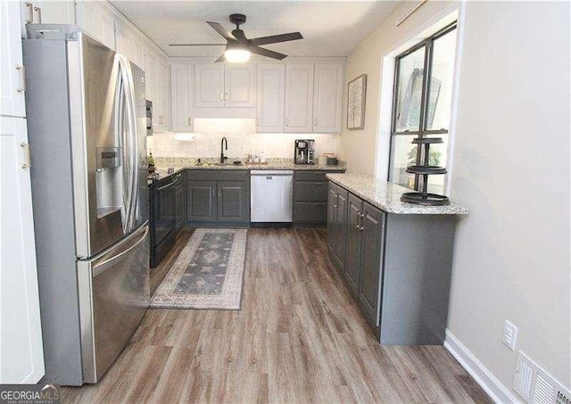 kitchen with stainless steel fridge, visible vents, electric range, dishwasher, and wood finished floors