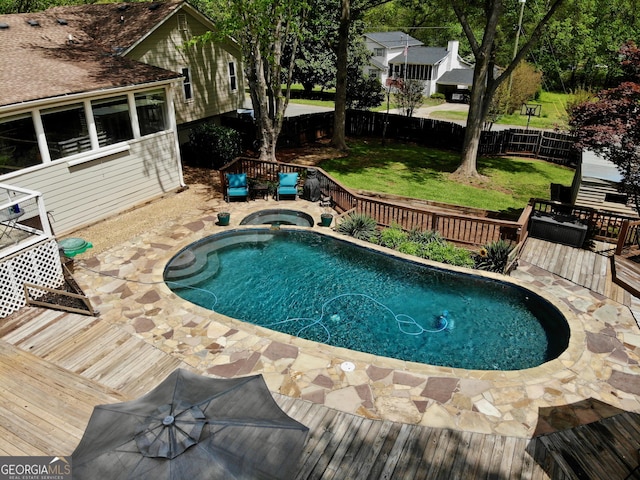 view of swimming pool featuring a fenced in pool, fence, a deck, a yard, and an in ground hot tub