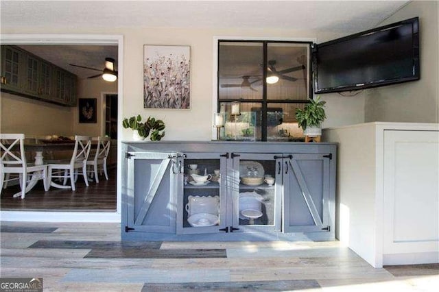 bar with wood finished floors and ceiling fan