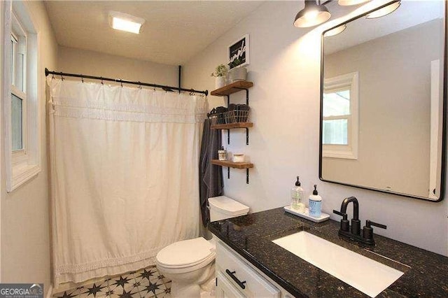 bathroom featuring toilet, tile patterned floors, vanity, and a shower with shower curtain