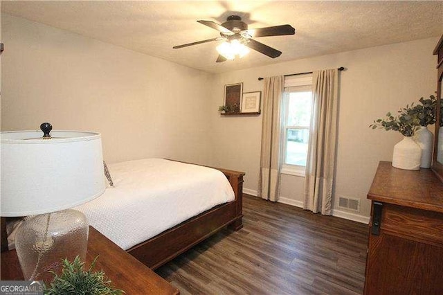 bedroom with wood finished floors, ceiling fan, visible vents, and baseboards