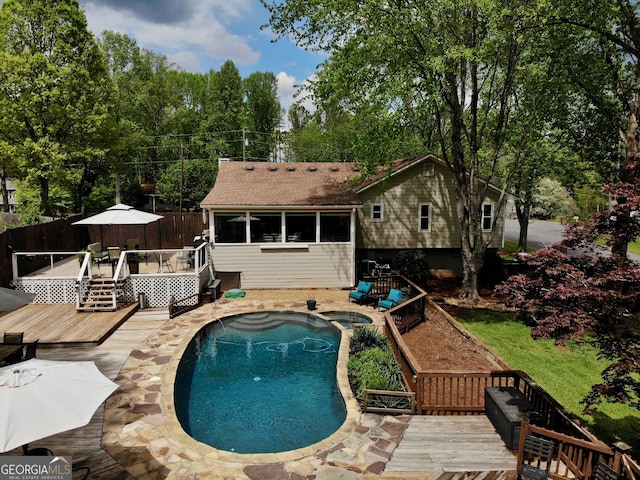 view of pool with a wooden deck, fence, a fenced in pool, and an in ground hot tub