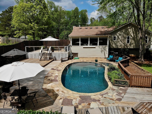 view of pool featuring a wooden deck, outdoor dining space, a fenced in pool, and fence private yard