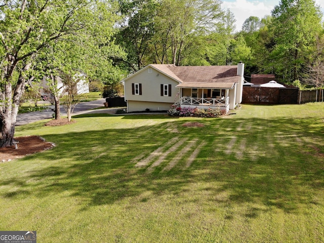 exterior space with a chimney, fence, a porch, and a front lawn