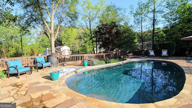 view of pool with fence, a patio, a deck, and a fenced in pool