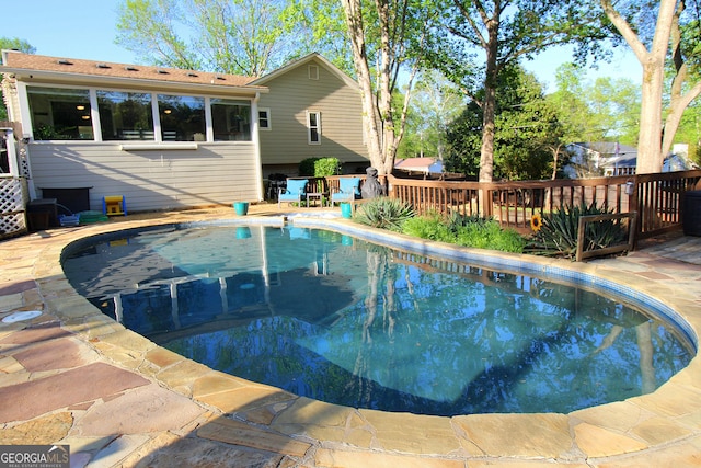view of pool with a fenced in pool and a deck