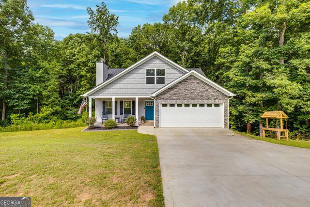 craftsman-style house with a front yard, stone siding, a garage, a chimney, and concrete driveway