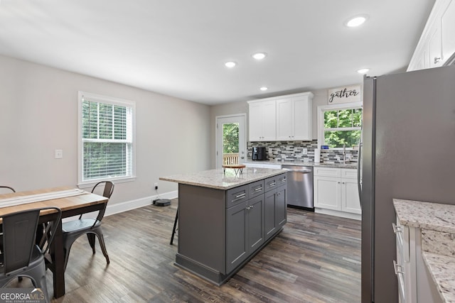 kitchen featuring white cabinets, dark wood finished floors, a center island, and appliances with stainless steel finishes