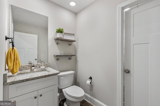 bathroom with vanity, baseboards, toilet, and wood finished floors