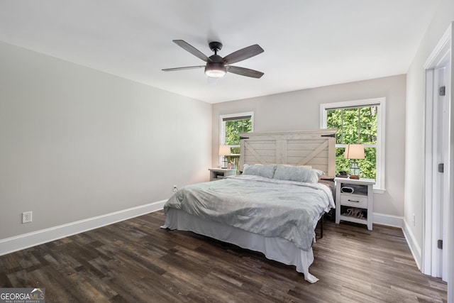 bedroom with dark wood finished floors, ceiling fan, baseboards, and multiple windows
