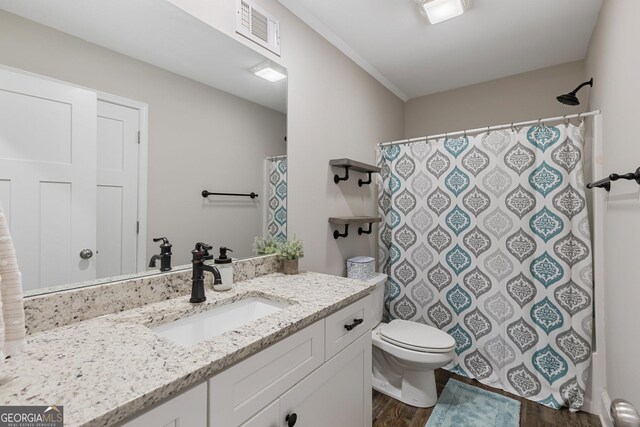 full bath with toilet, visible vents, wood finished floors, a shower with shower curtain, and vanity