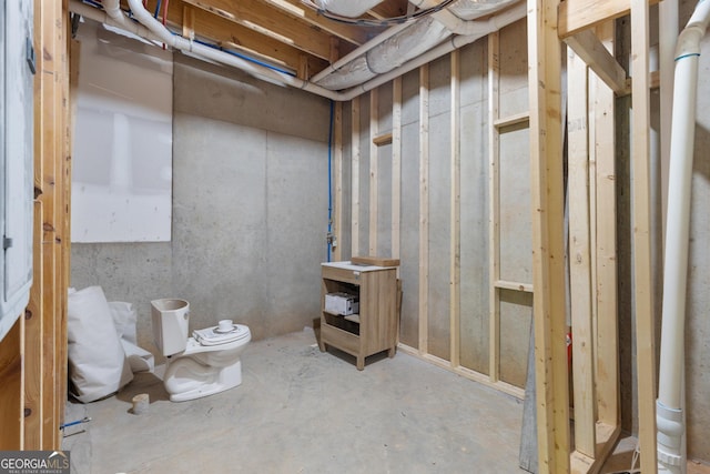 bathroom featuring concrete flooring and toilet