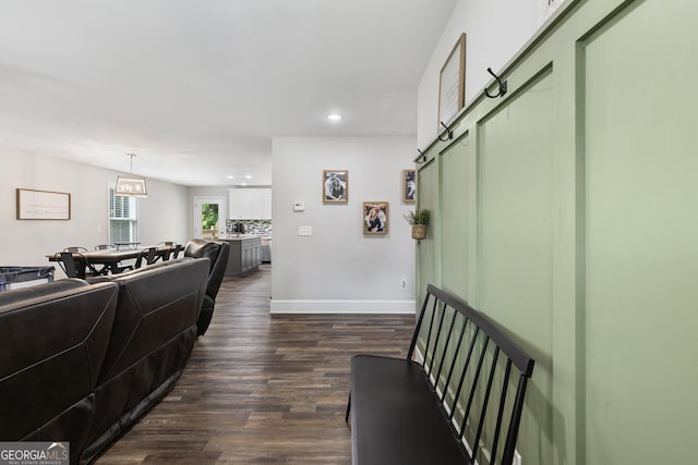 living room with recessed lighting, baseboards, dark wood-style floors, and an inviting chandelier