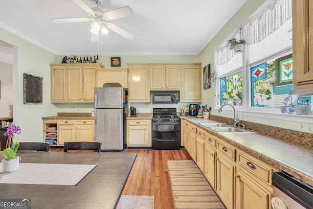 kitchen with a sink, a ceiling fan, crown molding, black appliances, and wood finished floors