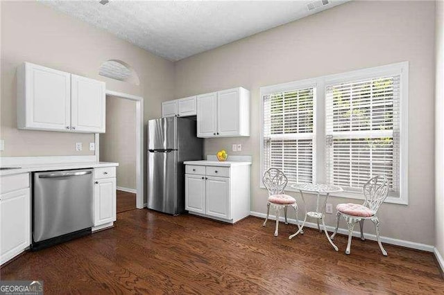 kitchen with white cabinets, light countertops, dark wood finished floors, and stainless steel appliances