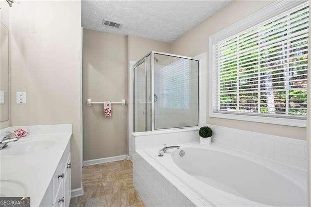 bathroom featuring a garden tub, a shower stall, visible vents, a sink, and double vanity