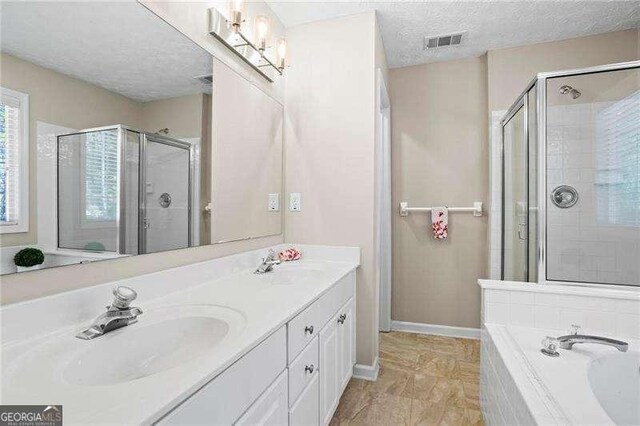 bathroom featuring vanity, visible vents, a stall shower, and a textured ceiling