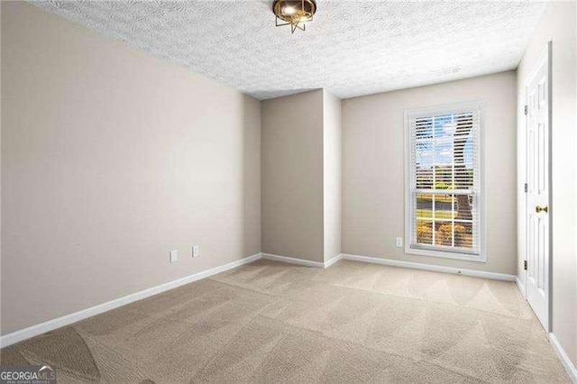 unfurnished room with a textured ceiling and carpet