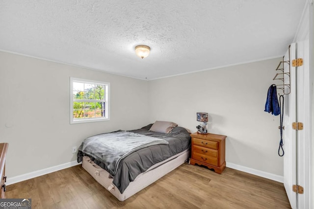 7310 Pea Ridge Pl, Gainesville, GA 30506 - bedroom featuring crown molding, a textured ceiling, wood finished floors, and baseboards