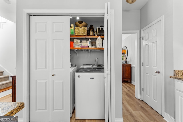 laundry room featuring light wood-type flooring, washer and dryer, and laundry area