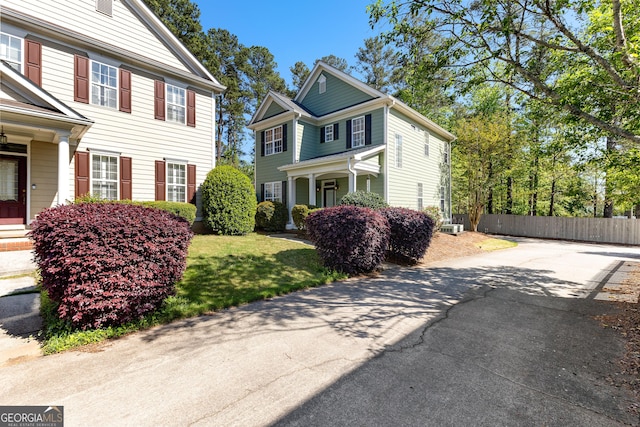 view of home's exterior featuring driveway and fence