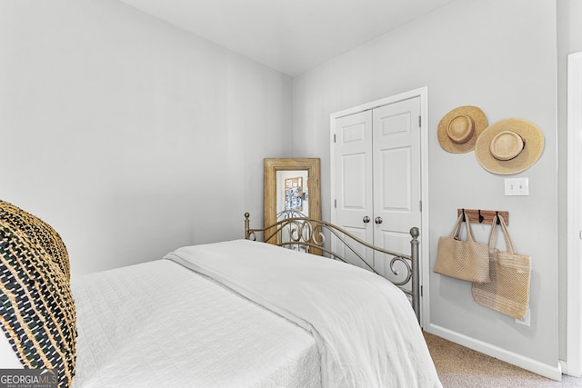 bedroom featuring a closet, baseboards, and carpet