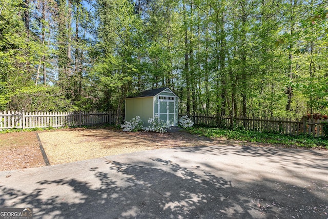 view of patio / terrace with an outbuilding, a fenced backyard, and a storage unit